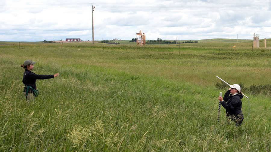 Researchers on prairie near oil facility